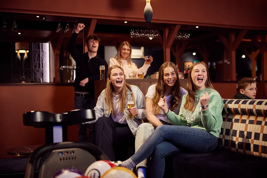 juichende mensen in de bowlingbaan na gooien van een strike