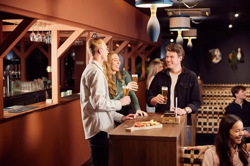 3 mensen borrelen bij bowlingbaan
