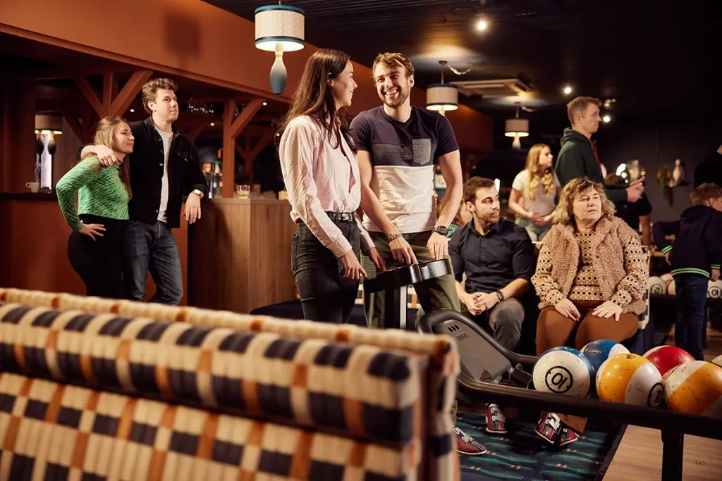 groepje mensen in de bowlingbaan die geniet van een avondje uit